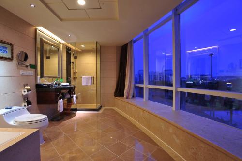 a bathroom with a toilet and a large window at The Royal Marina Plaza Hotel Guangzhou in Guangzhou
