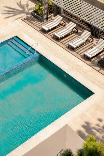 an overhead view of a swimming pool with chaise lounge chairs and a swimming pool at Brittany Hotel Villar City in Cavite