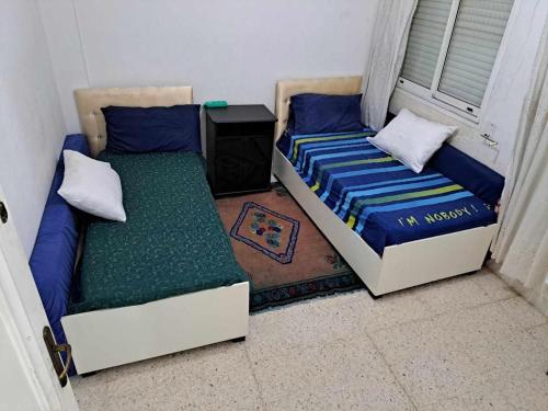 2 letti posti uno accanto all'altro in una stanza di appartement a sahloul sousse a Sousse
