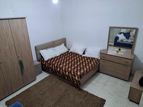 una camera da letto con un letto con specchio e un comò di appartement a sahloul sousse a Sousse