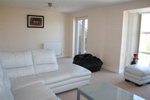 a living room with a white couch and a chair at Kandy Stay in Peterborough