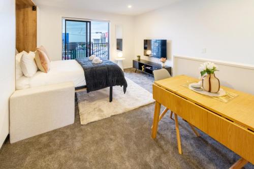 a bedroom with a bed and a table and a couch at Urban Retreat at 8 Wilmer: Upper Level Studio Gem in Christchurch
