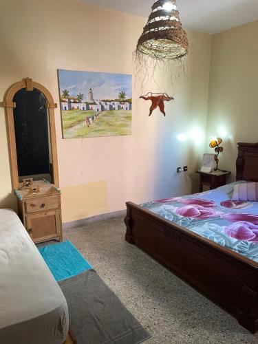 - une chambre avec un lit et une peinture murale dans l'établissement La Symbiose Essaouira, à Essaouira