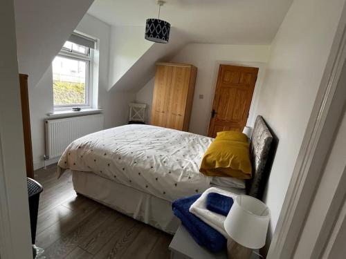sypialnia z łóżkiem z żółtą poduszką i oknem w obiekcie An Teach Bán w mieście Falcarragh