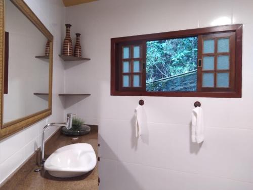 a bathroom with a sink and a window at Bromélia Sabiá & Cia in Teresópolis