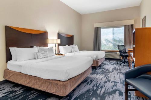 a hotel room with two beds and a window at Fairfield Inn & Suites by Marriott Commerce in Commerce