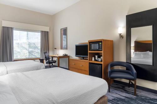 a hotel room with two beds and a television at Fairfield Inn & Suites by Marriott Commerce in Commerce