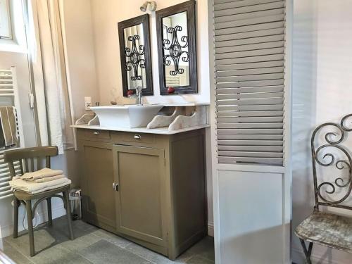 a bathroom with a sink and a mirror at Holiday home La Jardinerie in Aumeville-Lestre