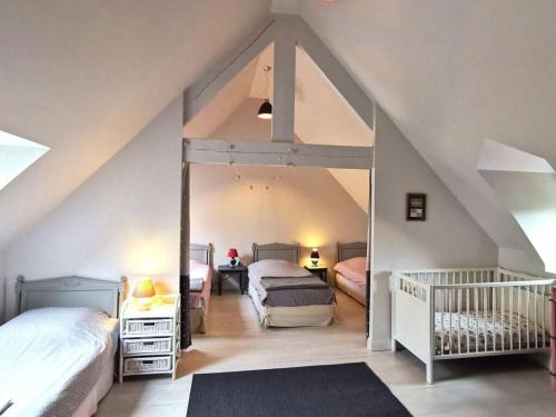 Aumeville-LestreにあるHoliday home La Jardinerieの屋根裏のベッドルーム(ベッド2台、鏡付)
