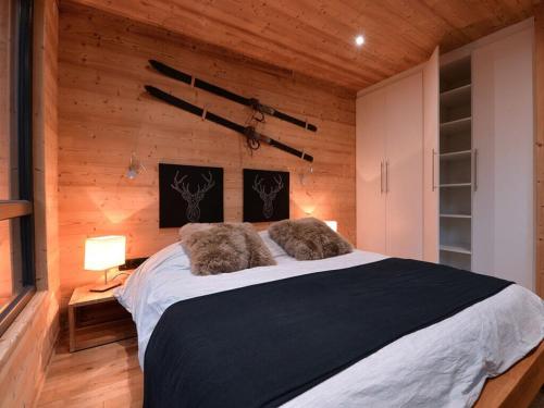 1 dormitorio con 1 cama grande y paredes de madera en Holiday home under the trees, en Labaroche