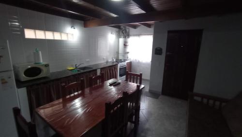 una cucina con un lungo tavolo in legno e sedie di Del muelle a Miramar