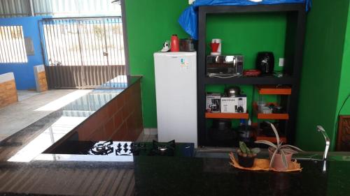 eine Küche mit grünen Wänden und einem weißen Kühlschrank in der Unterkunft POUSADA DO PORTAL in Rio Branco