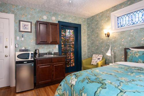 a bedroom with a bed and a sink and a kitchen at Prince Street Suites in Charlottetown