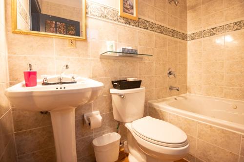 a bathroom with a toilet and a sink and a tub at Prince Street Suites in Charlottetown