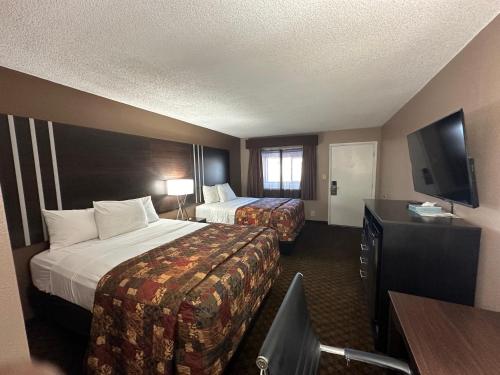 a hotel room with two beds and a flat screen tv at Star Inn in Tonopah