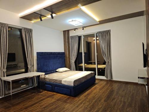 1 dormitorio con 1 cama, TV y sofá en STAY IN A LUXURIOUS VILLA AT AJMAN UAE BY MAUON TOURISM, en Al Ḩamīdīyah