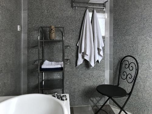 a bathroom with a tub and a chair and towels at Apartments by the sea Loviste, Peljesac - 22220 in Lovište
