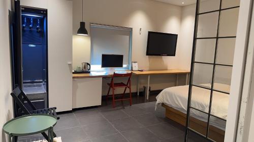 a room with a bed and a desk with a computer at Gwangju Hotel the spot in Gwangju