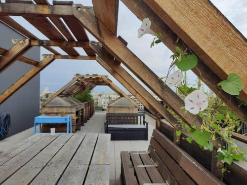 un toit-terrasse avec un banc en bois et des plantes dans l'établissement Sublime Appartement Proche JO 2024, à Saint-Denis