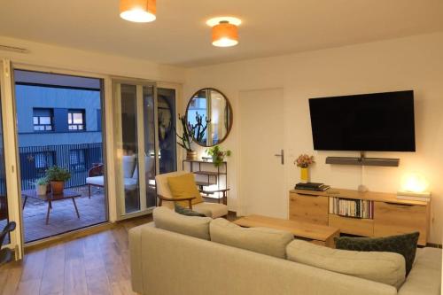 Il comprend un salon doté d'un canapé et d'une télévision à écran plat. dans l'établissement Sublime Appartement Proche JO 2024, à Saint-Denis