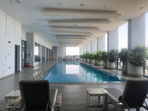 a large swimming pool in a building with chairs at Zhong Xin Hotel in Phnom Penh