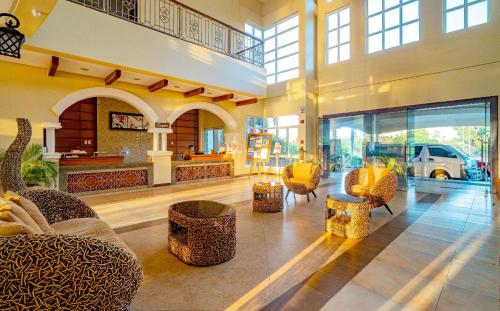 a lobby with couches and chairs in a building at Hotel Palacio Puerto Princesa in Puerto Princesa City