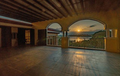 an empty room with a balcony with a view of the sunset at Hotel Palacio Puerto Princesa in Puerto Princesa City