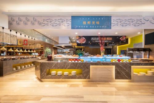 a restaurant with a counter with food on it at Holiday Inn Shijiazhuang Central, an IHG Hotel in Shijiazhuang