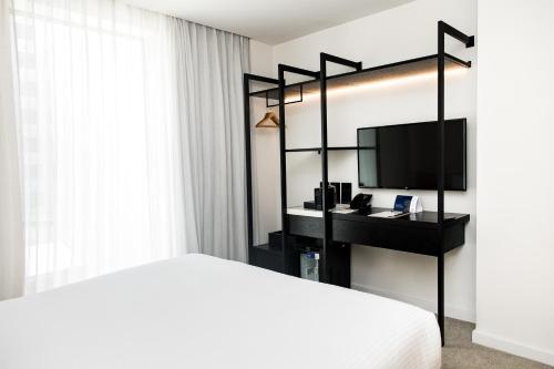 a bedroom with a bed and a desk with a television at Quay Perth in Perth