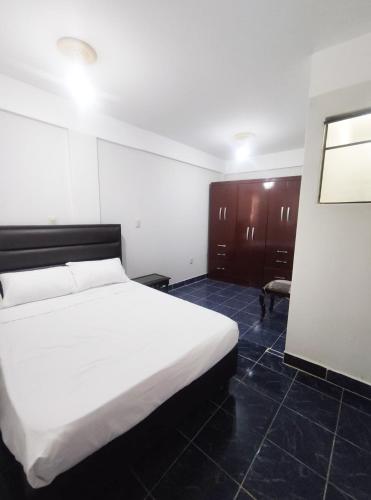 una camera con un grande letto bianco di Apartamento/Departamento Tarija a Tarija