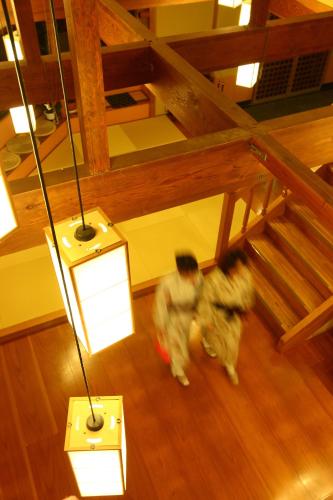 two people are walking in a room with lights at Hanashibuki in Tateyama