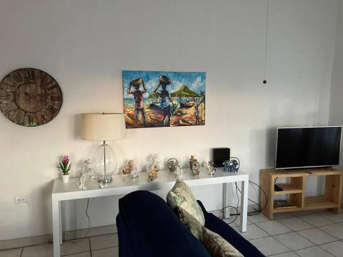 salon z kanapą i stołem z telewizorem w obiekcie The Residence - your home when not at home w Basseterre