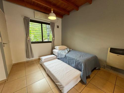 1 dormitorio con cama y ventana en El Nido Bombal en Godoy Cruz