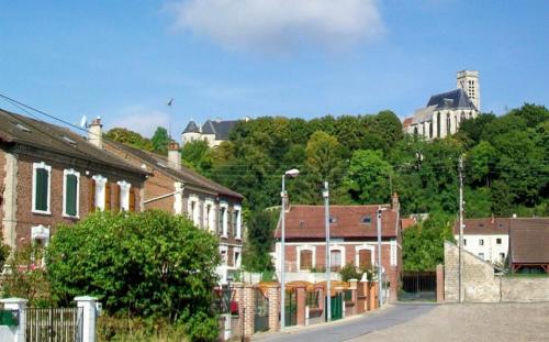 a group of brick houses in a town with buildings at Beau studio centre ville in Montataire
