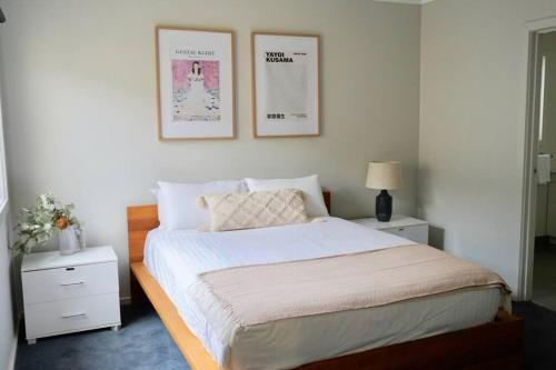 a bedroom with a bed and two pictures on the wall at Honeysuckle St Cottage. Central Location. Sleeps 8 in Bendigo