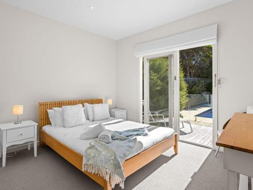 a bedroom with a bed and a sliding glass door at Bluetopia in Rye