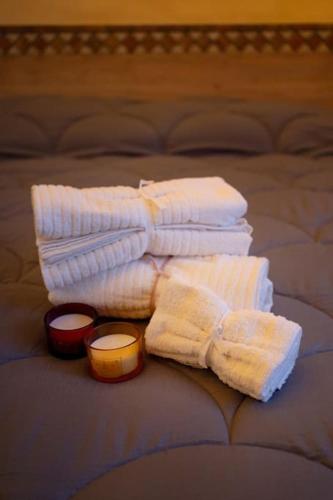 a pile of white towels and a candle on a bed at cs veniceflat Apartment - Venice - Apt Vce - 15' from Venice in Tessera
