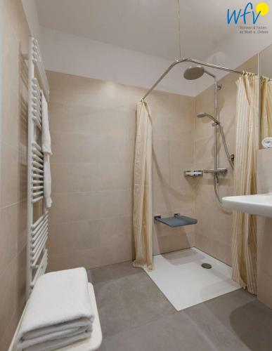 a bathroom with a shower and a sink at Haus am Hövt - Ferienwohnung 3 in Göhren