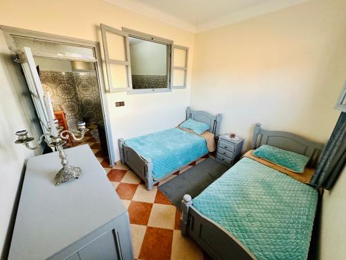 Apartment with 2 bedrooms في الصويرة: غرفة بسريرين وطاولة ومرآة