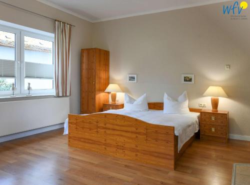 a bedroom with a large bed and a window at Haus am Hövt - Ferienwohnung 1 in Göhren