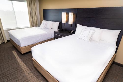 羅斯維爾的住宿－Residence Inn by Marriott Rocklin Roseville，配有白色床单的酒店客房内的两张床