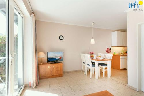 a kitchen and dining room with a table and chairs at Haus am Hövt - Ferienwohnung 11 in Göhren