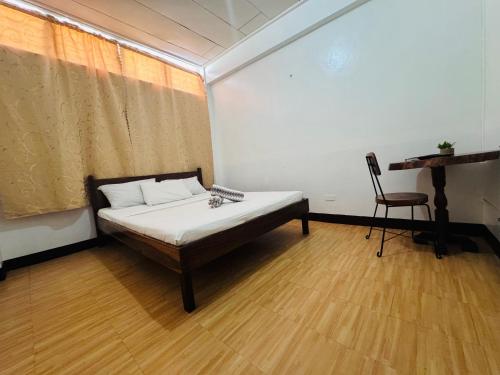 a room with a bed and a chair in it at Duchess Sophia's Pension in Puerto Princesa City