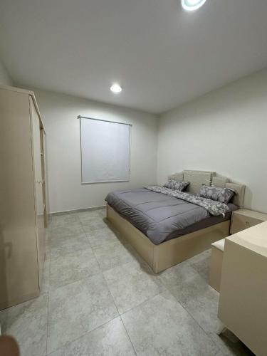 1 dormitorio con 1 cama y una pizarra en la pared en وحدة سكنية مع كراج خاص للسيارة, en Bīshat Mushayţ