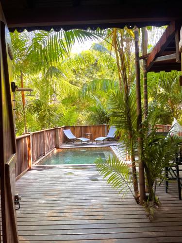 a swimming pool with chairs on a wooden deck at Ti Kaz Açaï in Le Lamentin