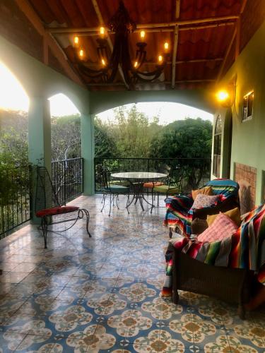 a room with a balcony with a table and chairs at The Traveler Palm B and B in El Limón
