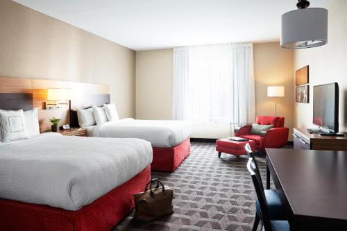 テハチャピにあるTownePlace Suites By Marriott Tehachapiのベッド2台とリビングルームが備わるホテルルームです。