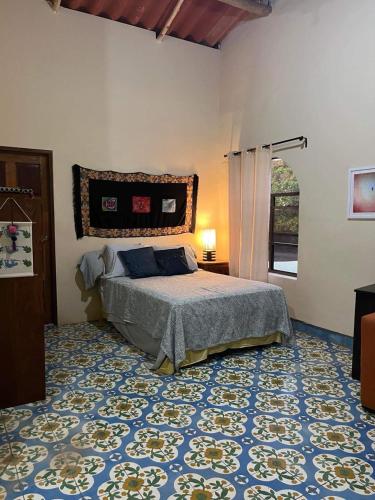 1 dormitorio con cama y alfombra azul en The Traveler Palm B and B en El Limón