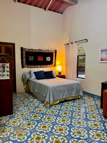a bedroom with a bed and a blue and white floor at The Traveler Palm B and B in El Limón