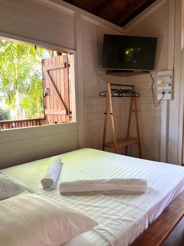 a bed in a room with a window and a television at Ti Kaz Açaï in Le Lamentin